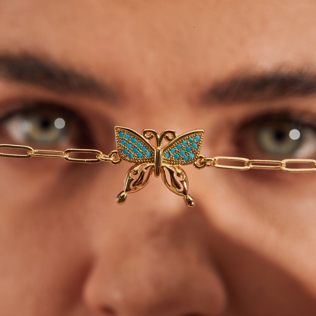 Butterfly charm bracelet being scrutinized by a model